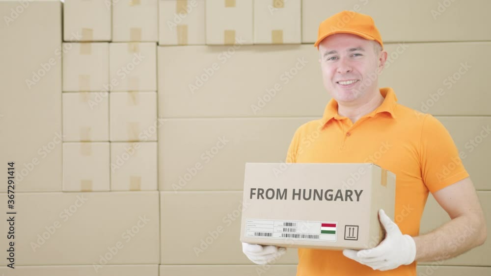 Poster warehouse worker holds cardboard box with printed from hungary text on it