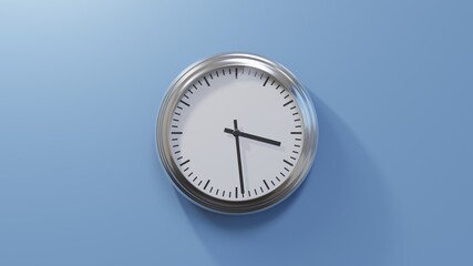 Glossy chrome clock on a blue wall at twenty-nine past three. Time is 03:29 or 15:29