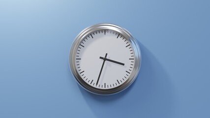 Glossy chrome clock on a blue wall at thirty-three past three. Time is 03:33 or 15:33
