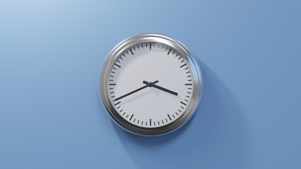 Glossy chrome clock on a blue wall at forty-one past three. Time is 03:41 or 15:41