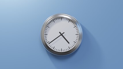 Glossy chrome clock on a blue wall at thirty-nine past four. Time is 04:39 or 16:39