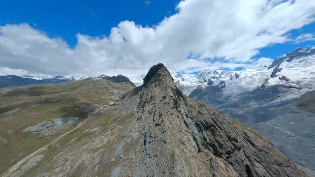 Stunning Landscape While Climbing Over The Rocky Riffelhorn Summit Revealing The Gornergletscher Glacier Under The Blue Sky In Zermatt, Switzerland - aerial drone