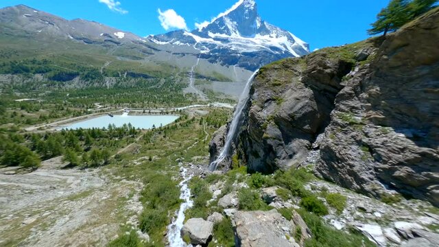 Flying Towards The Beautiful And Pristine Waterfall With The Matterhorn Summit In The Background In Zermatt, Switzerland - FPV drone
