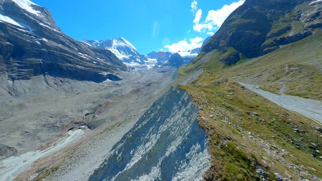 Overflying The Zmuttgletscher Glacier Lateral Moraine And The Outwash Plain, Sandur With A Flowing River In Zermatt Switzerland, FPV drone footage