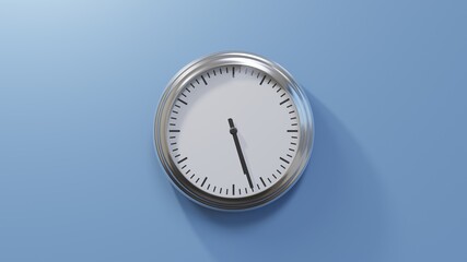 Glossy chrome clock on a blue wall at twenty-seven past five. Time is 05:27 or 17:27
