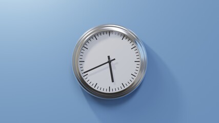 Glossy chrome clock on a blue wall at forty-one past five. Time is 05:41 or 17:41