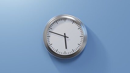 Glossy chrome clock on a blue wall at forty-eight past five. Time is 05:48 or 17:48