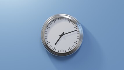 Glossy chrome clock on a blue wall at twelve past seven. Time is 07:12 or 19:12