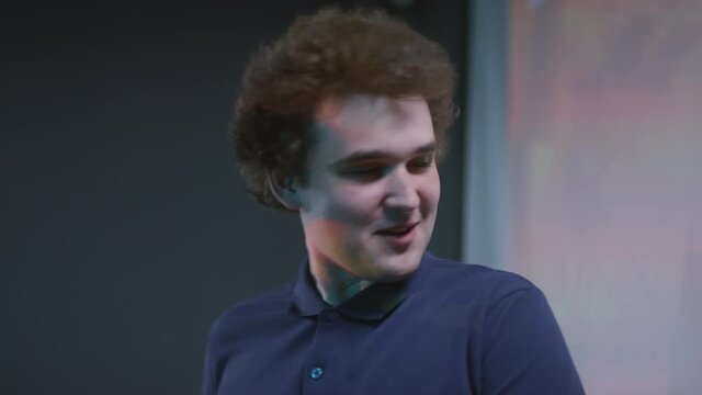 Slow motion portrait shot footage of young male gamer with curly hair sharing his ideas about new strategy