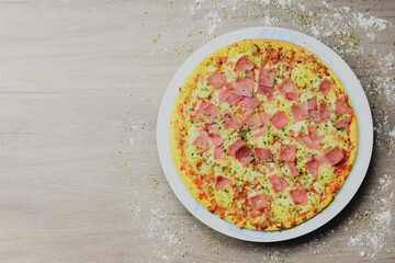 Pizza with cheese and sweet ham, on wooden table, space for text