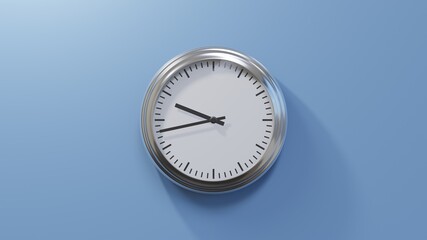 Glossy chrome clock on a blue wall at forty-three past nine. Time is 09:43 or 21:43