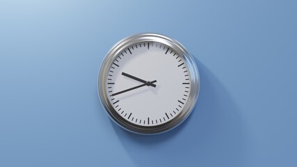 Glossy chrome clock on a blue wall at forty-two past nine. Time is 09:42 or 21:42