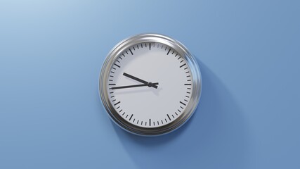 Glossy chrome clock on a blue wall at forty-four past nine. Time is 09:44 or 21:44
