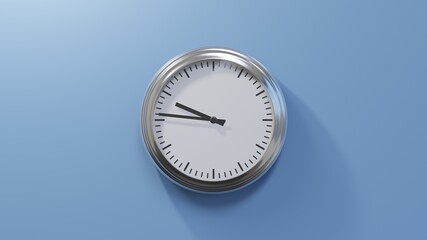 Glossy chrome clock on a blue wall at forty-six past nine. Time is 09:46 or 21:46