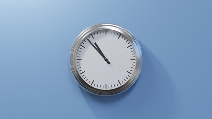 Glossy chrome clock on a blue wall at fifty-three past ten. Time is 10:53 or 22:53