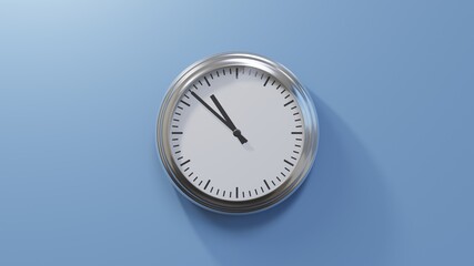 Glossy chrome clock on a blue wall at fifty-two past ten. Time is 10:52 or 22:52