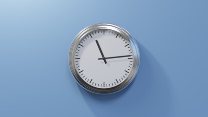 Glossy chrome clock on a blue wall at fourteen past eleven. Time is 11:14 or 23:14