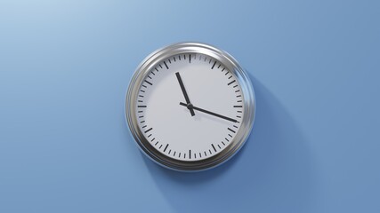Glossy chrome clock on a blue wall at eighteen past eleven. Time is 11:18 or 23:18