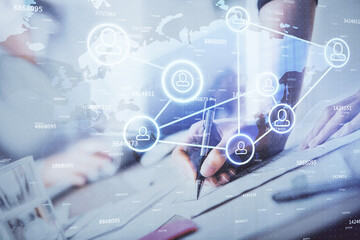 Social network theme hologram over hands taking notes background. Concept of global international people connect. Double exposure