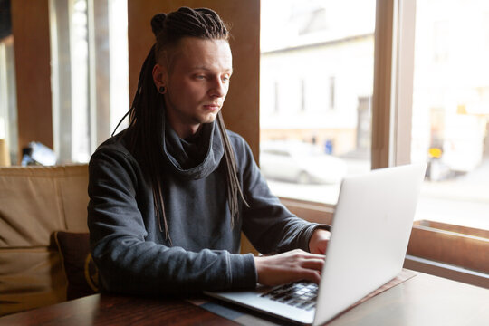 Young Businessman with dreadlock having doing his work in cafe with laptop.