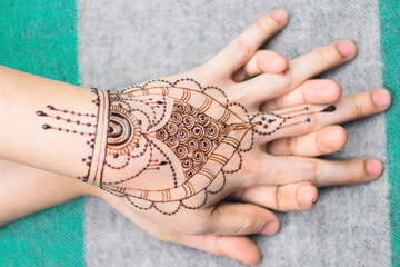 Artist applying henna tattoo on women hands. Mehndi is traditional Indian decorative art. Close-up