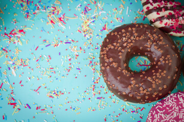 Multicolored sweet donuts with colourful decoration on blue background.