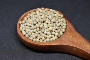 White pepper grains isolated on black background
