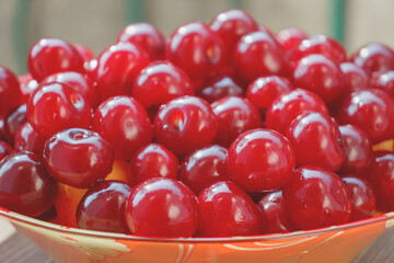 Bright sweet cherry berries in a plate. Vitamin gifts of a warm summer. Healthy natural delicacy.
