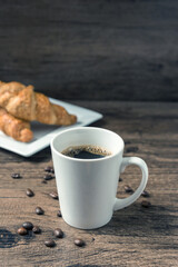 coffee break, White coffee cup, croissants on wood table background, selective focus. Breakfast concept