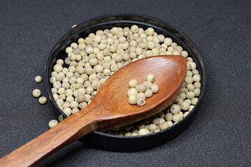 White pepper grains isolated on black background