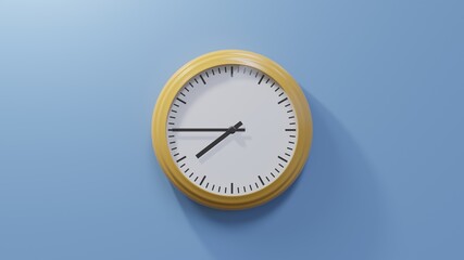 Glossy orange clock on a blue wall at quarter to eight. Time is 07:45 or 19:45