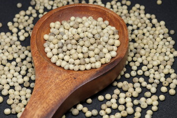 White pepper grains isolated on black background