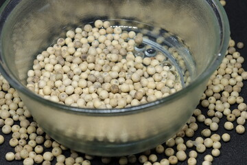 White pepper grains isolated on black background