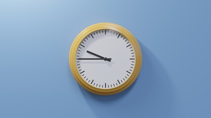 Glossy orange clock on a blue wall at quarter to ten. Time is 09:45 or 21:45