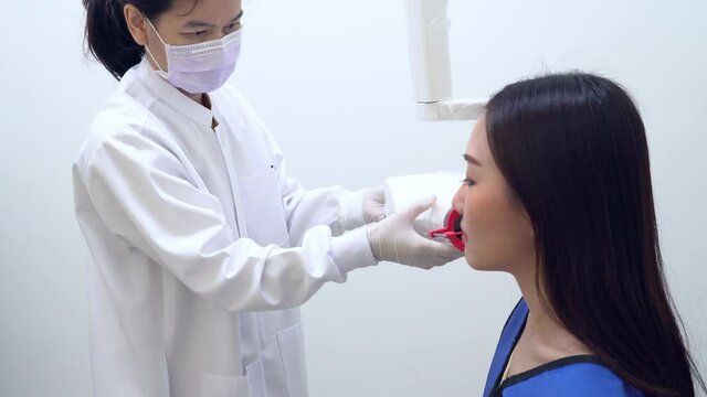 dentist assistant shooting film x-ray of tooth of asian woman in the dental clinic in hospital. dentistry and healthcare concept