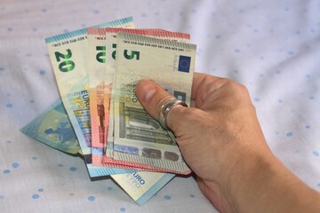 Mano con dinero en tiempos de crisis económica