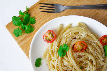 Spaghetti with cherry tomatoes and cheese on a wood board