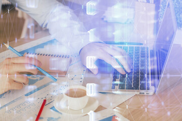 Multi exposure of data internet theme hologram with man working on computer on background. Concept of innovation.