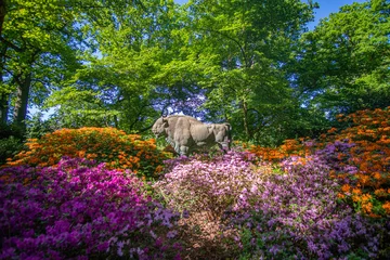 Papier Peint photo Lavable Azalée Bull Statue surrounded by beautiful blooming rhododendrons at Park in Bremen