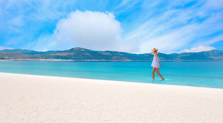 Beautiful girl in white swimsuit walks on a beach - Salda turqoise lake - Burdur,  Turkey