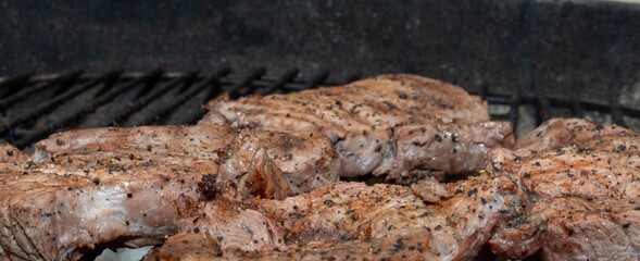 Beef steak being cooked on a South African Braai or Barbeque