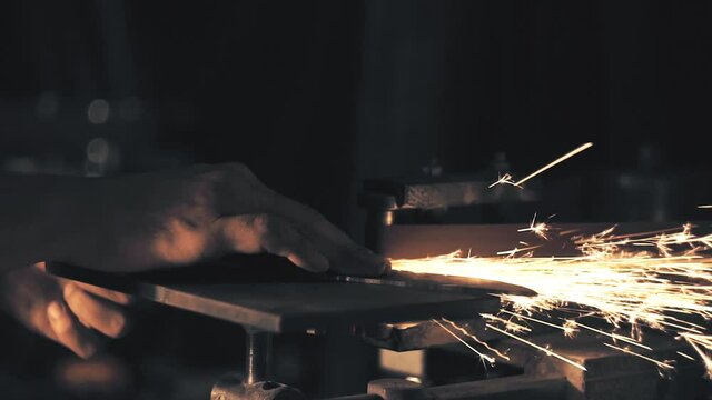Man sharpening knife with sparks
