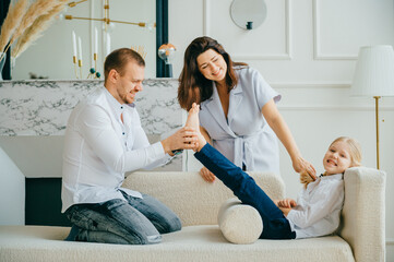 Cheerful parents plays with their child at home