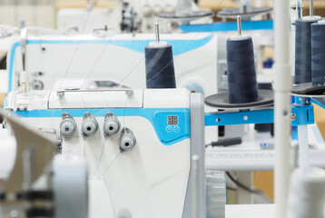 Close up of sewing process on the overlock in the sewing shop. Tailoring industry.. interior of garment factory shop.