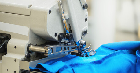 Close up of sewing process on the overlock in the sewing shop. Tailoring industry.. interior of garment factory shop. Closes making atelier with sewing machines.