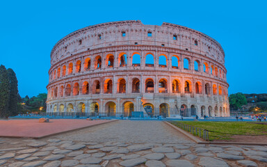 Fototapeta na wymiar Colosseum amphitheater in Rome at twilight blue hour with all columns completed - Rome, Italy