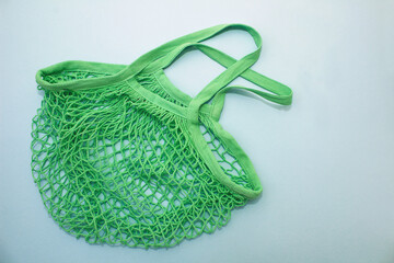 Cotton green mesh bag on blue paper background