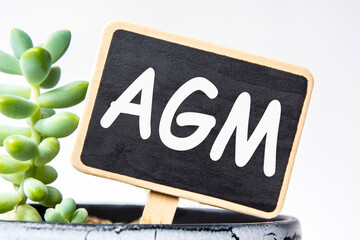 small black chalk board in a pot with succulents inscribed in white letters agm. business concept,...