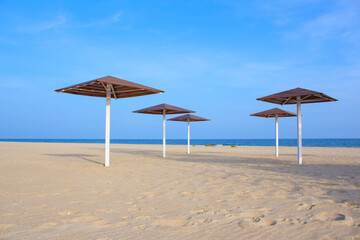 Umbrellas on the empty sandy beach . Coast without vacationers