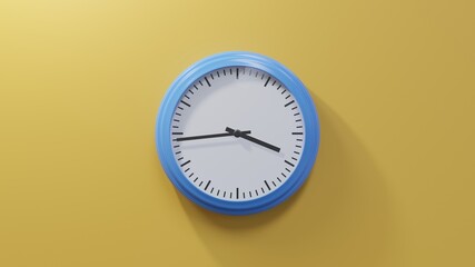 Glossy blue clock on a orange wall at forty-four past three. Time is 03:44 or 15:44